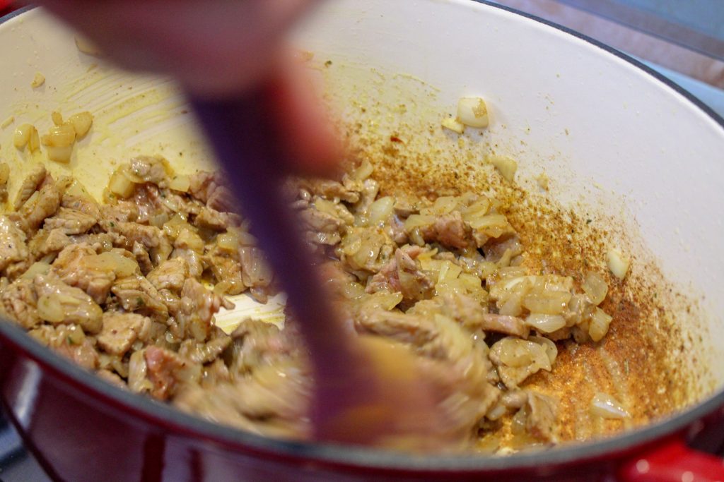 meat and onion cooking in a pot.